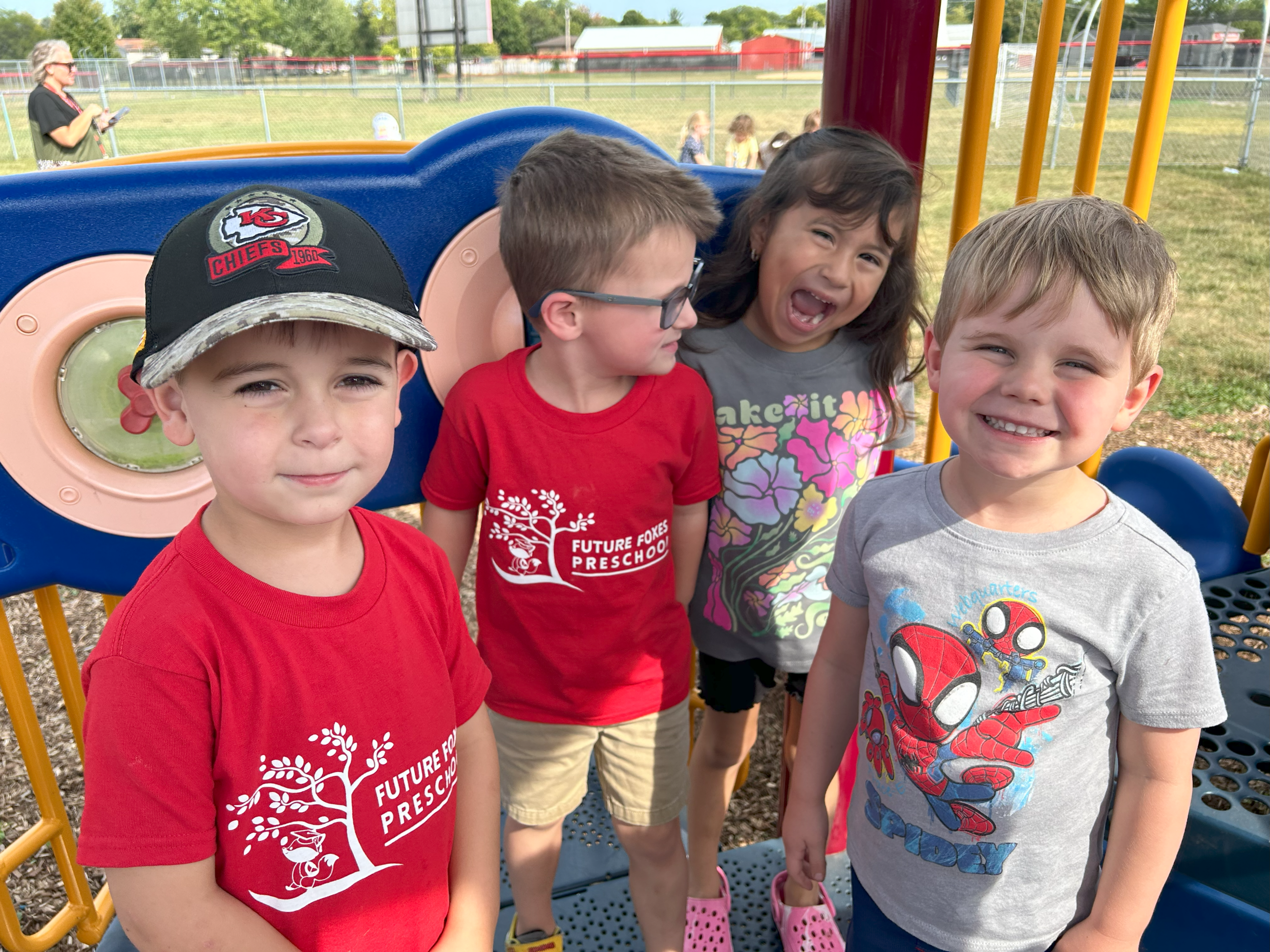 Four students playing together on the playground.