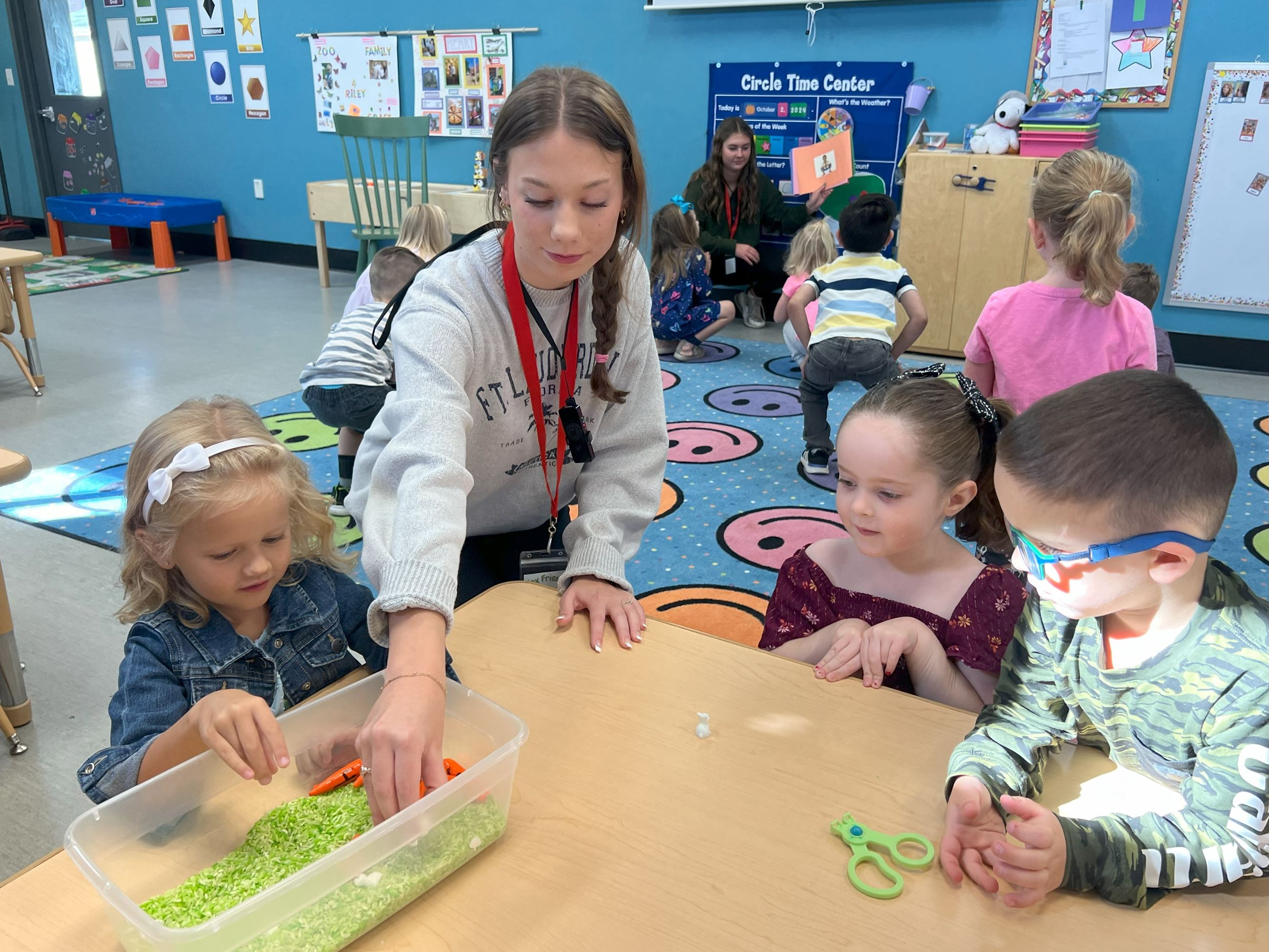 A high school student helping a preschooler learn. 