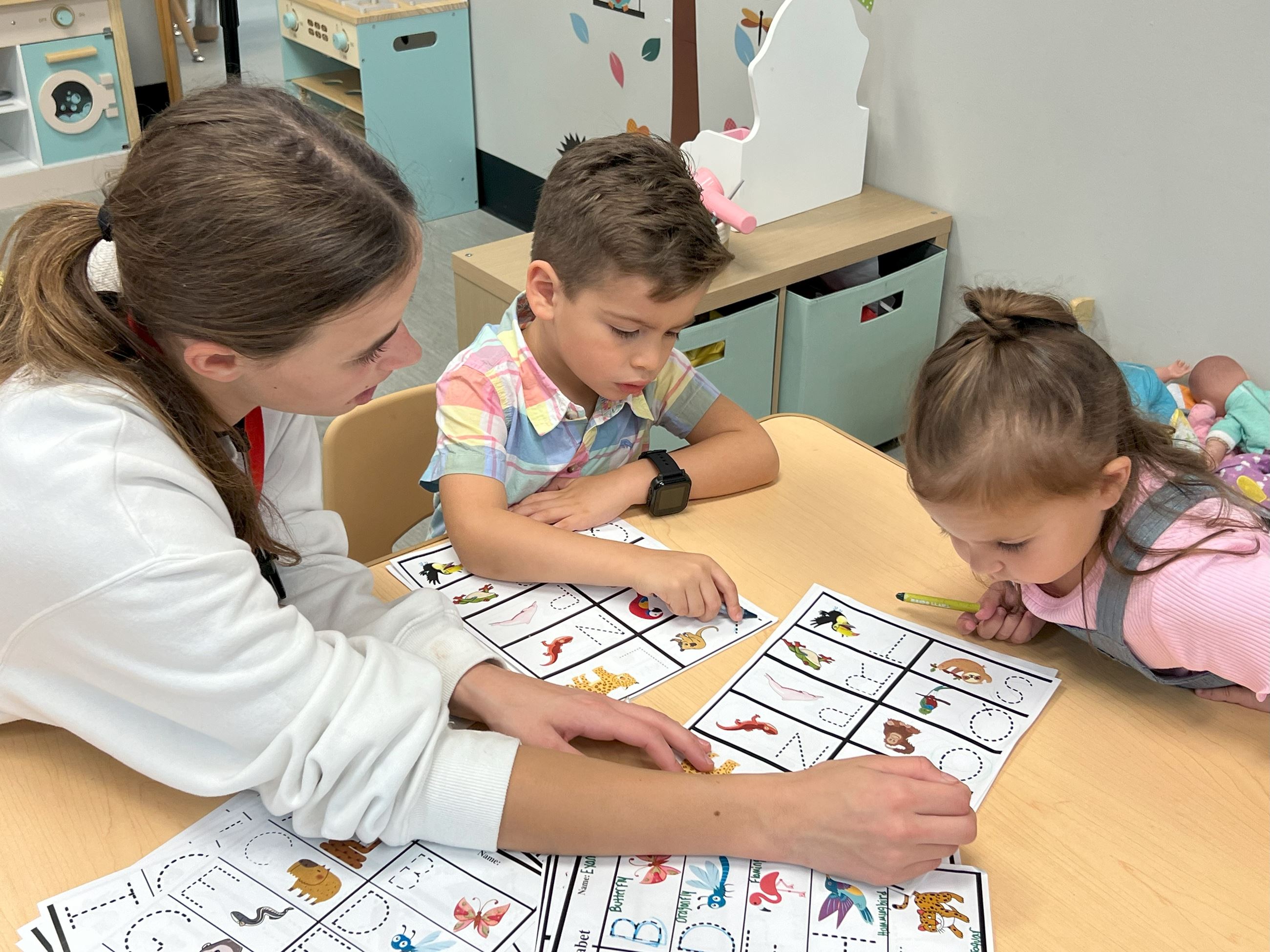 A high school student helping a preschooler learn. 